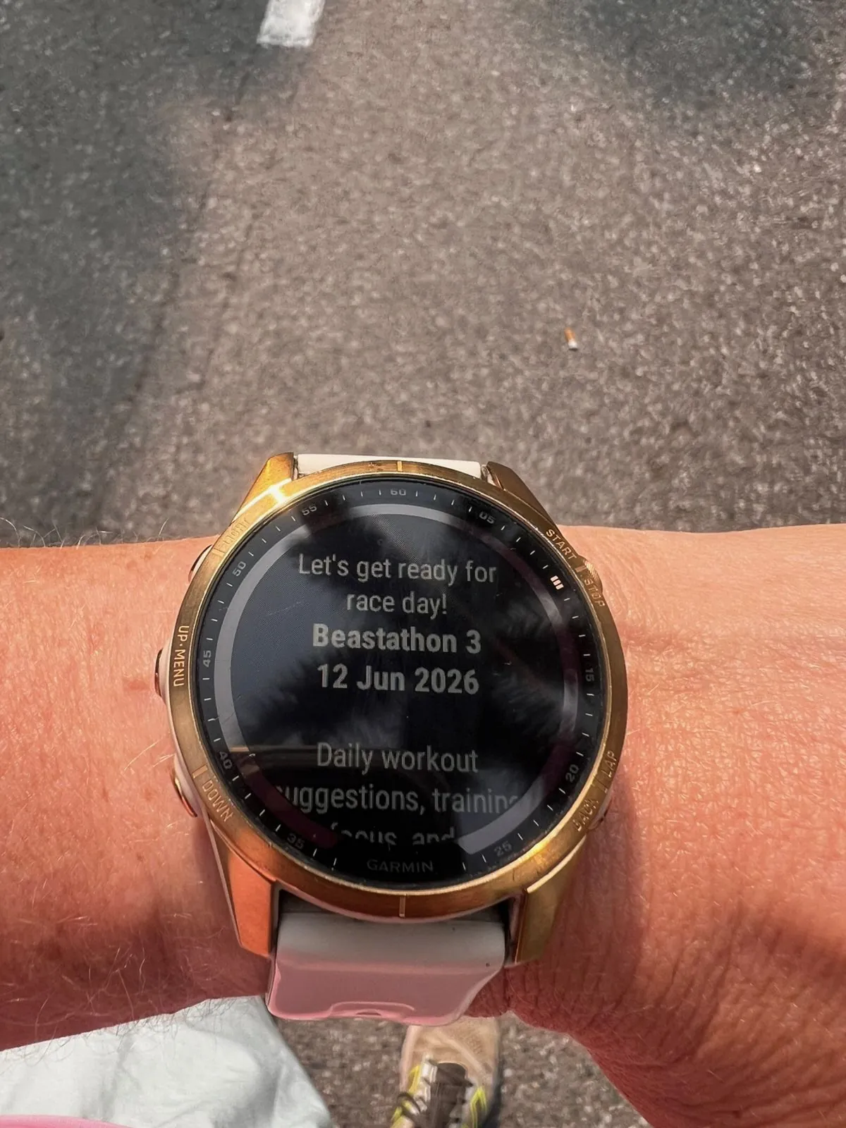 Garmin hardloophorloge op de pols toont een trainingsscherm voor race day tijdens een run.